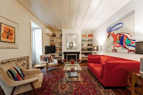 a living room with a red couch and a fireplace at Eighteen21 Houses - Casa de São Domingos in Lisbon
