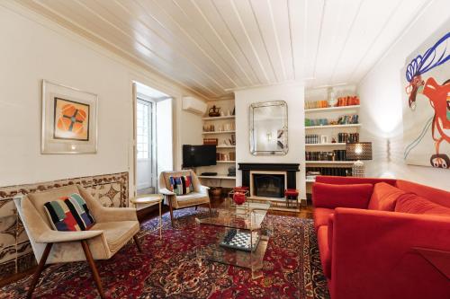 a living room with a red couch and a fireplace at Eighteen21 Houses - Casa de São Domingos in Lisbon
