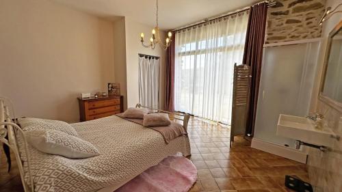 a bedroom with a bed and a large window at Fayollas in Bussière-Galant
