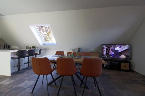 a dining room with a table and a tv at WK7 "Ferienwohnung Küstenruhe" in Dorum