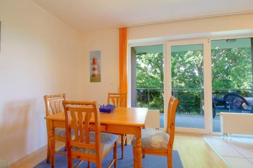 a dining room with a wooden table and chairs at Lilli Marleen WE 26 in Wremen