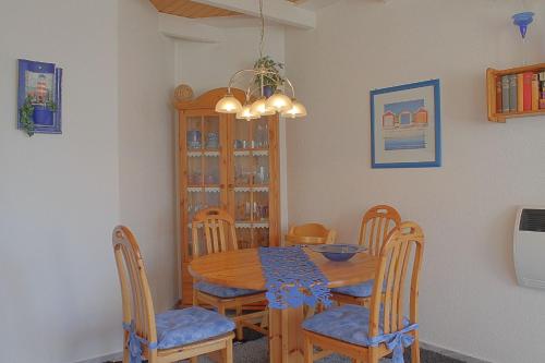 a dining room with a wooden table and chairs at STW45b Bungalow Seestern in Dorum-Neufeld