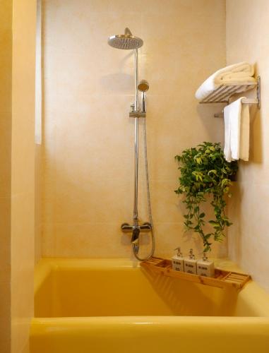 a bathroom with a yellow bath tub with a plant at Tasme Dalat Stay in Da Lat