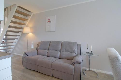 a living room with a couch and a staircase at KW4 Haus Anna in Dorum-Neufeld