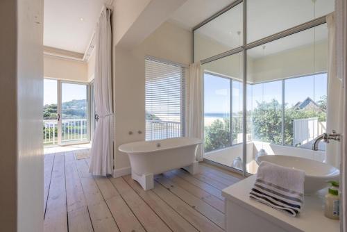 a white bathroom with a tub and a sink at 53 Island Road in Seafield