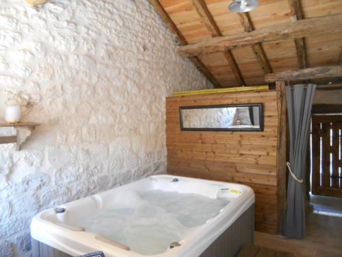 a bath tub in a bathroom with a wooden ceiling at Gîte du Clos de Gamel in Lascabanes