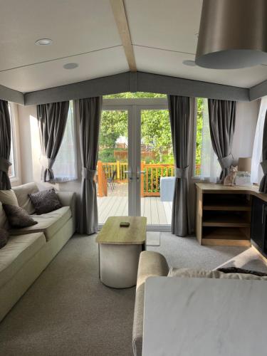 a living room with a couch and a table at 23 The Brambles - Haven Cleethorpes Beach in Humberston