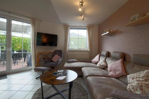 a living room with a couch and a table at LT 33 Bungalow Manu in Dorum-Neufeld