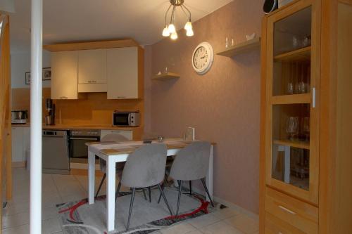 a kitchen with a table and chairs and a clock on the wall at LT 33 Bungalow Manu in Dorum-Neufeld