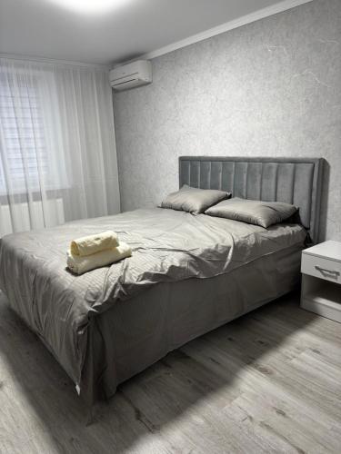 a bedroom with a large bed with a gray headboard at New apartment Căușeni in Căuşeni