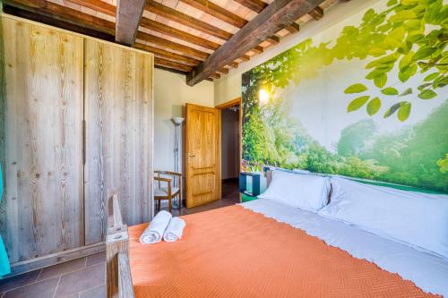a bedroom with a bed with a large painting on the wall at Casale Rialto in Montefalco