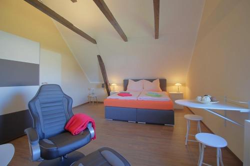 a bedroom with a bed and a chair and a table at Gästehaus Dorum 05 in Dorum