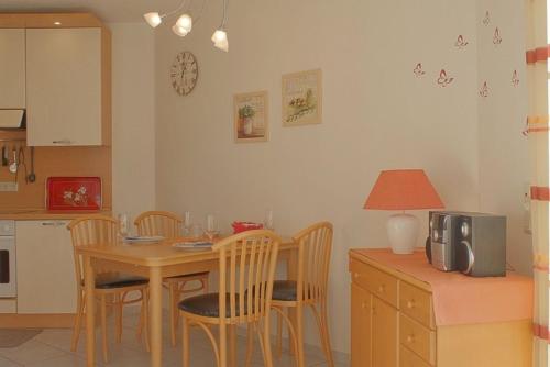 a kitchen with a wooden table and chairs and a table and a kitchen at LT35 Bungalow Moritz in Dorum-Neufeld