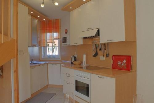 a kitchen with white cabinets and a red appliance at LT35 Bungalow Moritz in Dorum-Neufeld