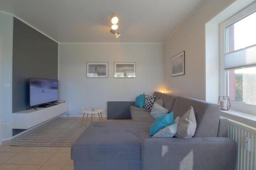 a living room with a couch and a tv at SI5-01 Terrassenwohnung Deichnah in Cappel-Neufeld