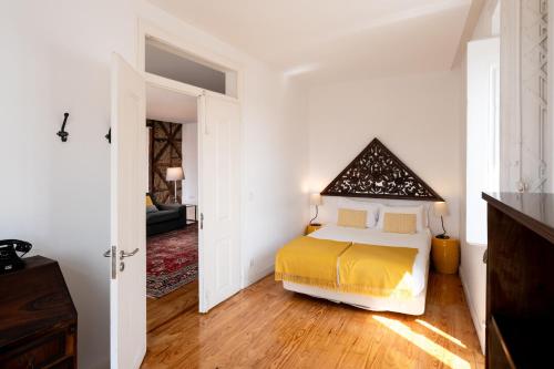 a bedroom with a bed with a yellow bedspread at Eighteen21 Houses - Casa de São Paulo in Lisbon