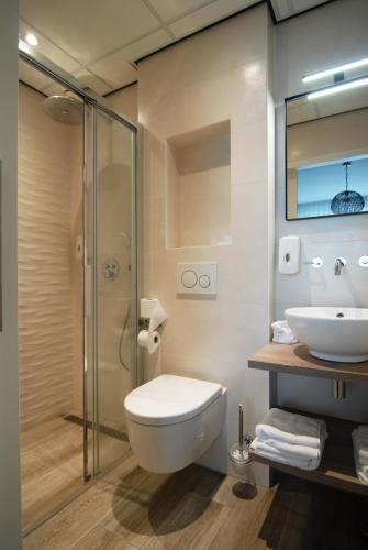 a bathroom with a sink and a toilet and a shower at Hotel Inkelshoes in Epen