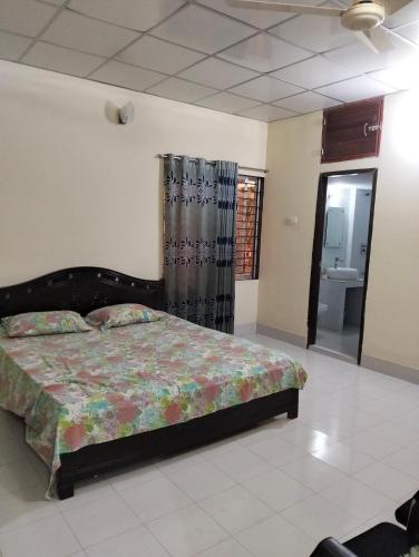 a bedroom with a bed and a bathroom at Mini Banglo in Sylhet
