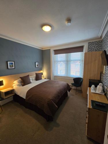 a bedroom with a large bed and a window at Hazeldene Guest House in Perth