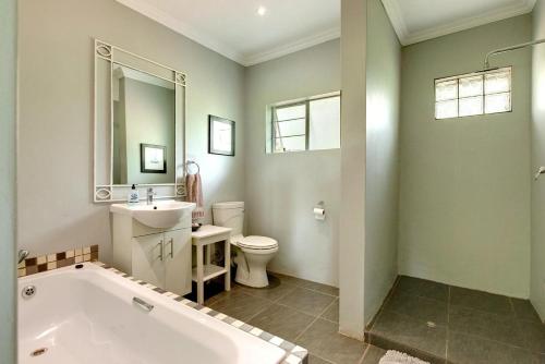 a bathroom with a tub and a toilet and a sink at Vaal River House @ Lochvaal in Vanderbijlpark