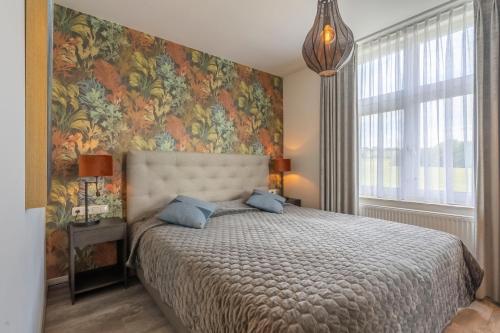 a bedroom with a large bed with a floral wallpaper at Hotel Inkelshoes in Epen