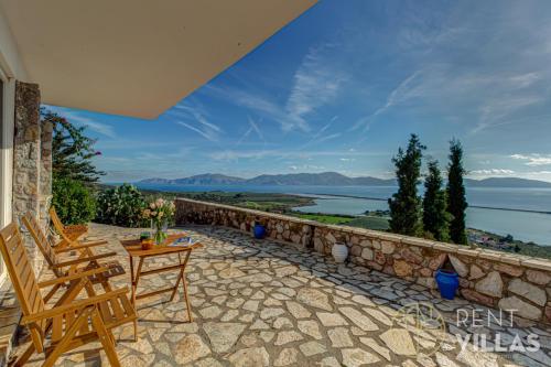 a patio with chairs and a table and a view of the water at Villa Karima with Sea View in Metókhion