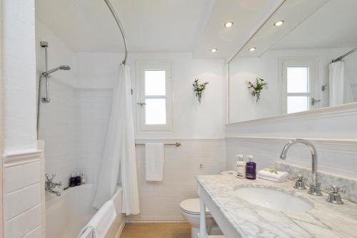 a white bathroom with a sink and a toilet at Spartilas Villas in Pyrgi