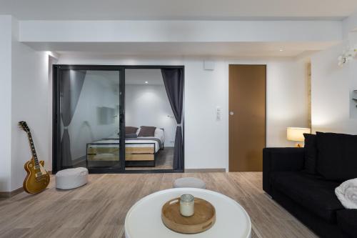 a living room with a black couch and a guitar at Cosy Home in Antibes