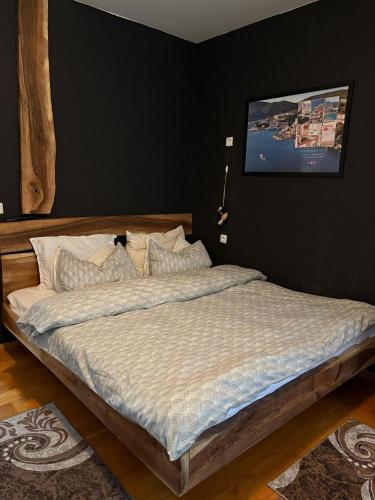 a bed in a bedroom with a black wall at Forest Dream Bjelasnica in Bjelašnica