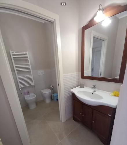 a bathroom with a sink and a toilet and a mirror at Casa Tella in Pula