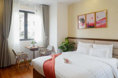 a hotel room with a bed with a stuffed animal on it at Tasme Dalat Stay in Da Lat