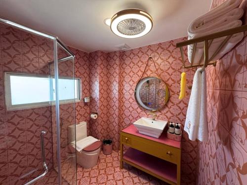 un bagno rosa con lavandino e doccia di Casa de Capybara a Siem Reap