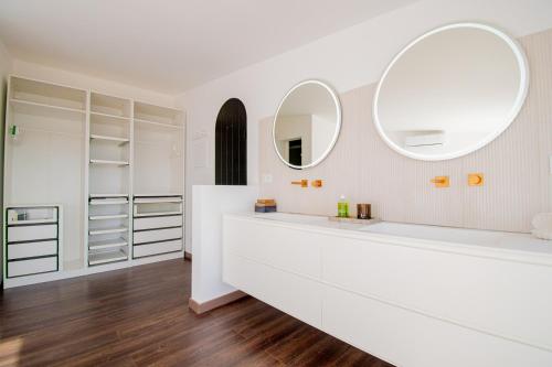 a bathroom with white cabinets and a large mirror at 14 Travessa das Naus in Carvoeiro