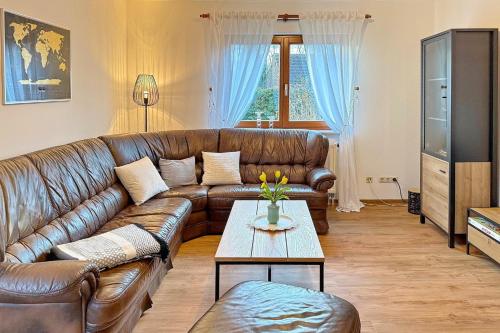 a living room with a leather couch and a table at Landlust in Lübbenau