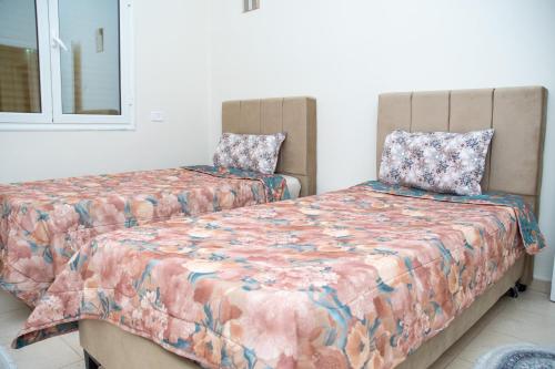 a bedroom with two beds and a mirror at Dar Gamra in Tozeur