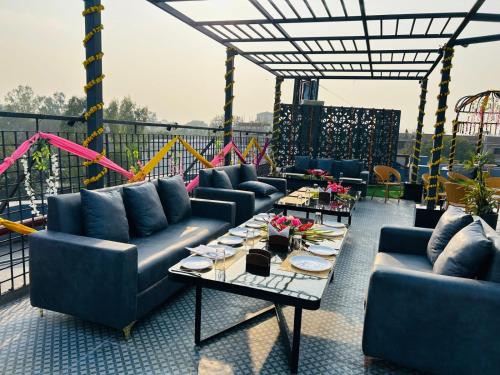 a patio with couches and a table on a balcony at Hotel President in Agra
