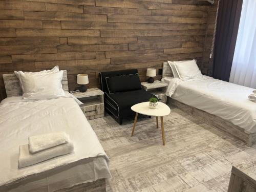a room with two beds and a chair and a table at Къща за гости Бъчвата in Elkhovo