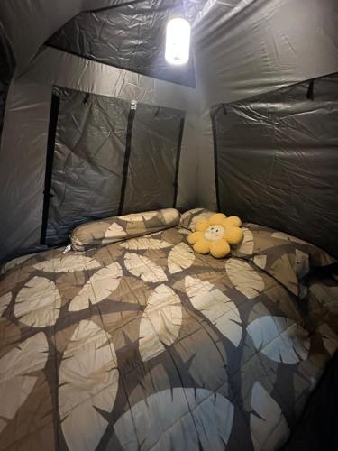 a stuffed animal laying on a bed in a tent at Stay Like a Local เต็นท์บ้านเรา in Chiang Mai