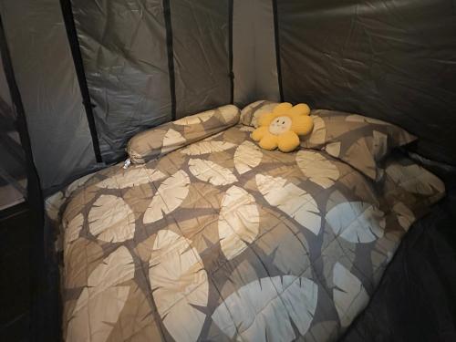 a teddy bear laying on a bed in a tent at Stay Like a Local เต็นท์บ้านเรา in Chiang Mai