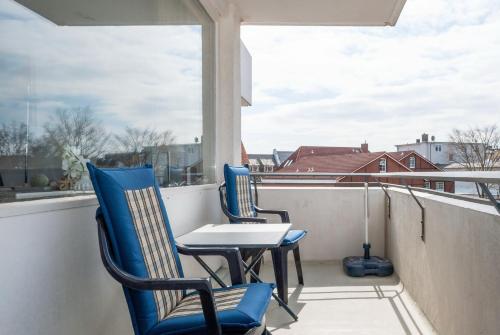 a balcony with two chairs and a table and a window at Hanseatic 204 in Duhnen