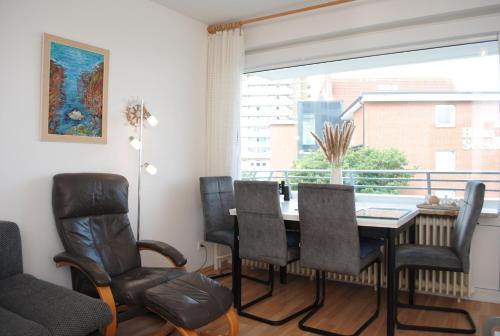 a dining room with a table and chairs and a window at Hanseatic 204 in Duhnen