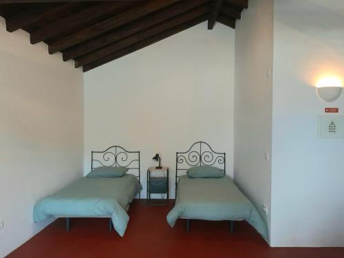 two beds in a room with white walls at Casas do Hastim in Golegã