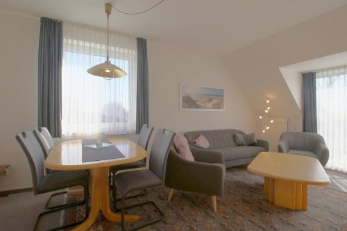 a living room with a table and chairs and a couch at KD2-07 Schiffsjunge in Dorum-Neufeld