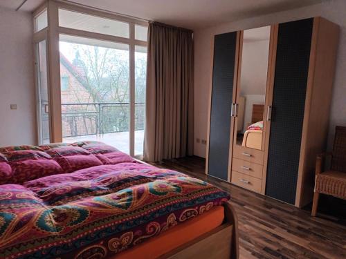 a bedroom with a large bed and a large window at Apartment am Vechtesee in Schüttorf