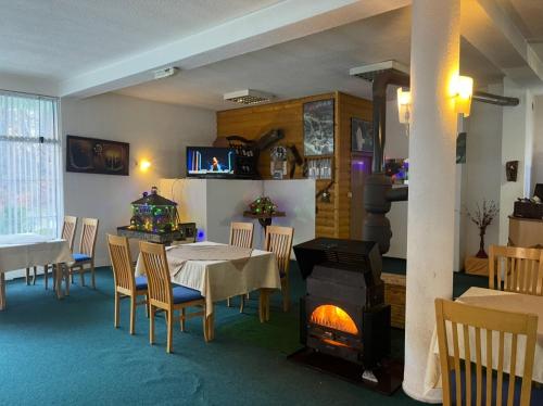 a dining room with a table and a fireplace at Hotel Gryka in Peje