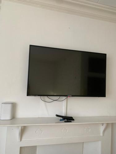 a flat screen tv hanging on a white wall at Self contained Studio apartments in Eastbourne