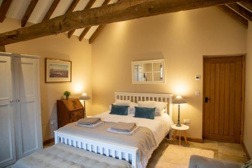 a bedroom with a large bed with blue pillows at The Cowshed in Hooe