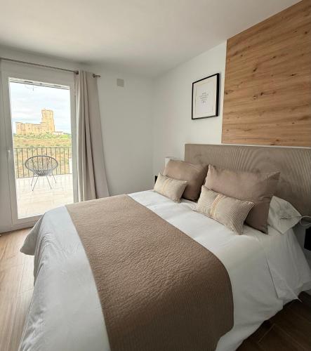 a bedroom with a large bed with a large window at Casa Puerta del Valle in Belalcázar