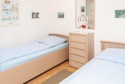 a bedroom with two beds and a night stand at Hanseatic 512 in Duhnen