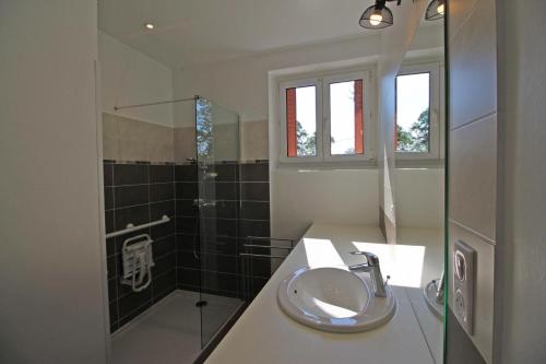 a bathroom with a sink and a shower at La fontaine in Saint-Mathieu